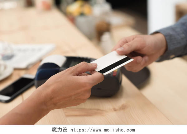 裁剪的客户端在咖啡馆付账单时将信用卡给服务员镜头
